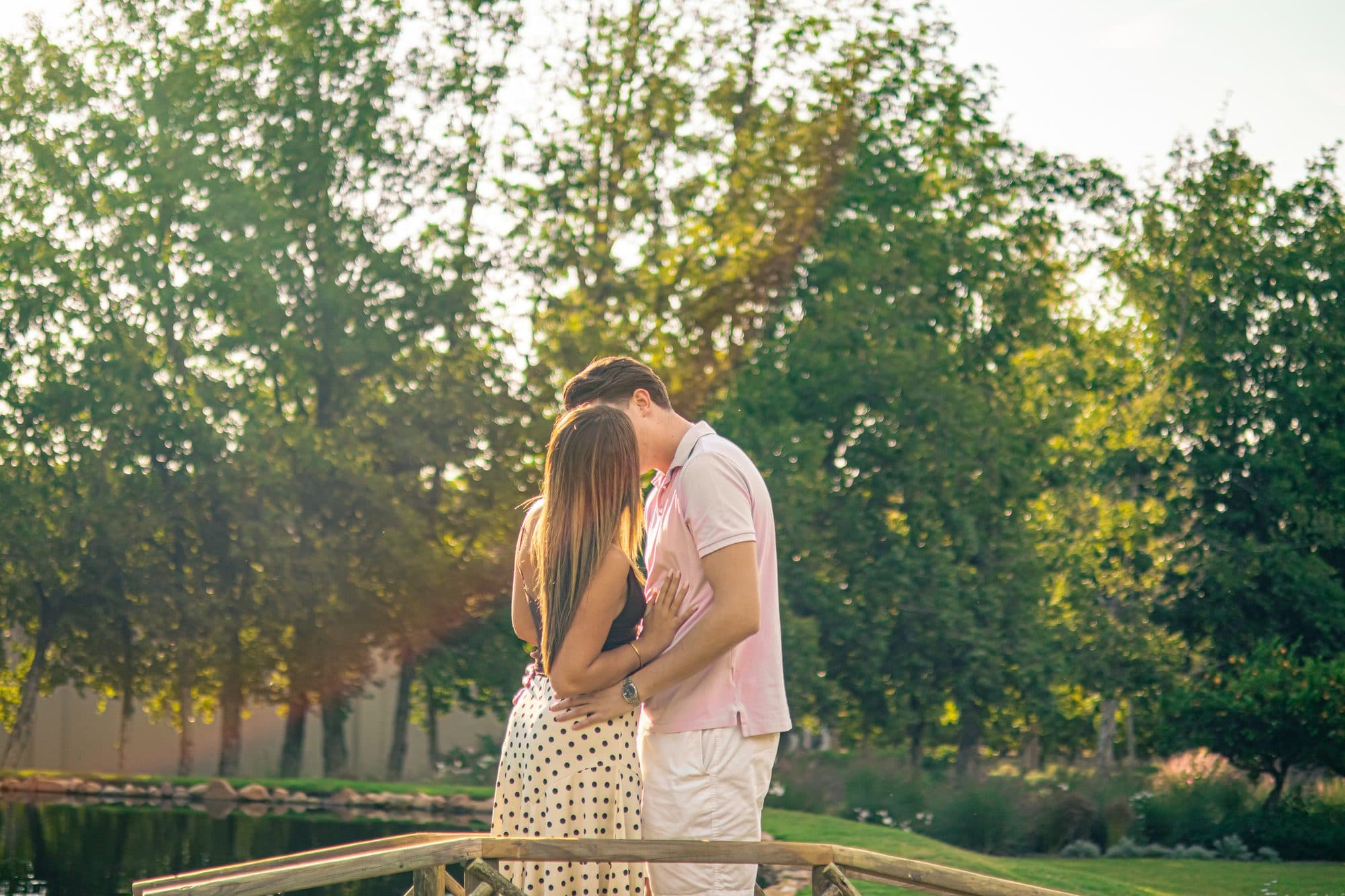 Sebastiano and Cecilia embracing on a wooden bridge among trees